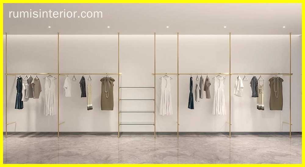 FLEEK custom retail clothing displays: Elegant gold clothing racks showcasing apparel in a modern retail space. - RUMIS