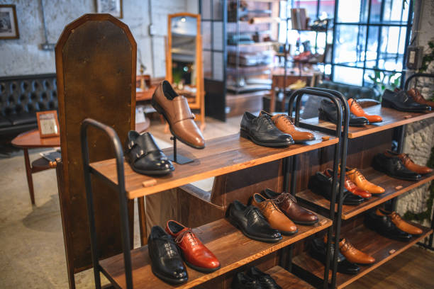 Stylish shoe table display showcasing a variety of men's leather shoes in brown and black.  The display features several shelves with neatly arranged footwear.