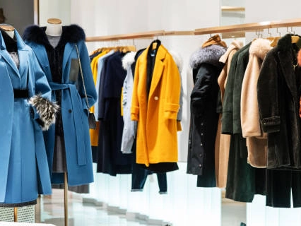 Clothing rack with shelves displaying stylish winter coats.