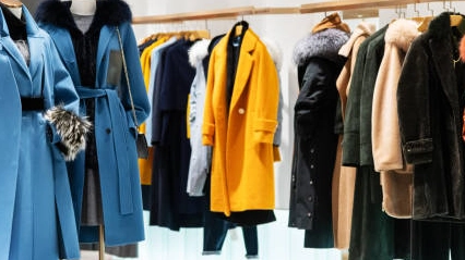 Clothing-rack-with-shelves-displaying-stylish-winter-coats. Clothing rack with shelves displaying stylish winter coats.