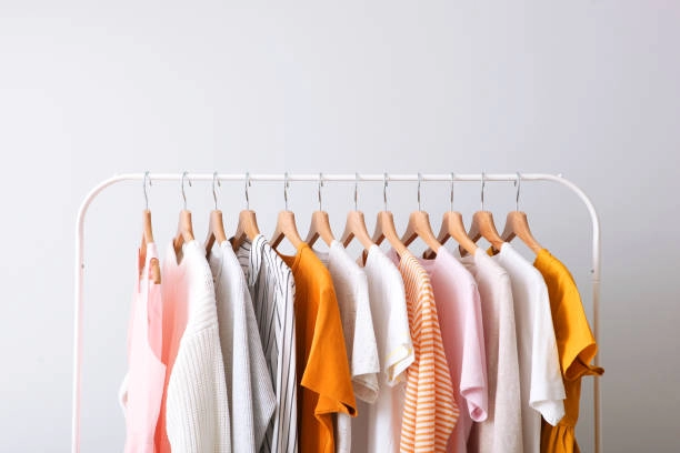 Clothing rack with shelves displaying colorful summer clothes.