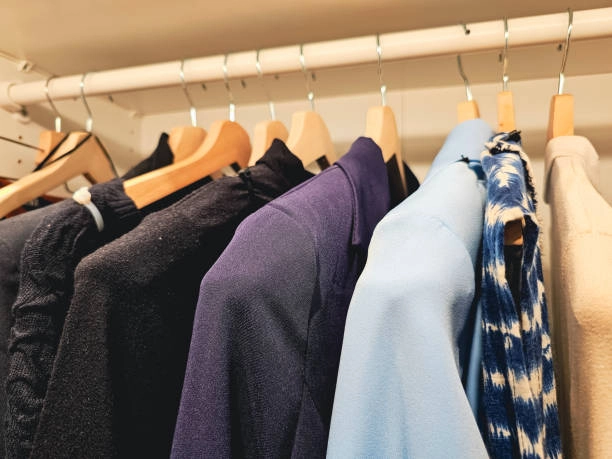 Clothing-rack-with-shelves-holding-folded-and-hanging-clothes. Clothing rack with shelves holding folded and hanging clothes.