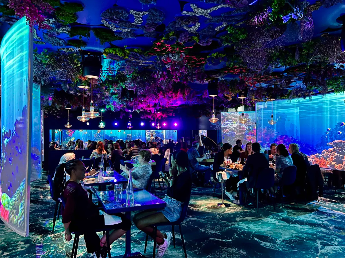 Diners enjoy the ambiance of an immersive restaurant with ocean views.