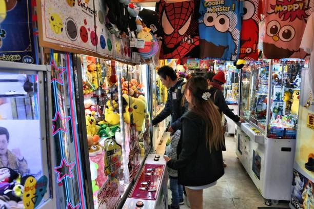 A claw machine in an arcade enhances the overall entertainment experience, drawing repeat customers and keeping players engaged with fun, prize-winning challenges.