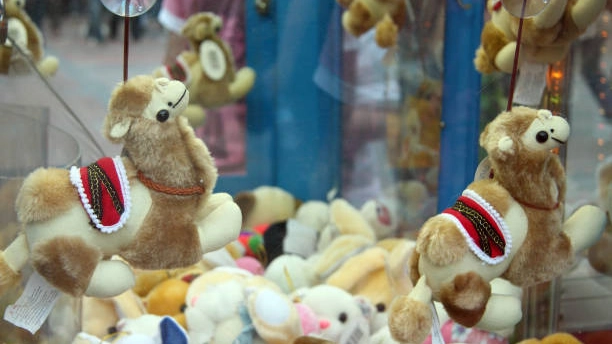 Custom claw machine with cute plush camel toys.