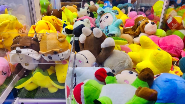 Arcade games claw machine filled with plush toys.