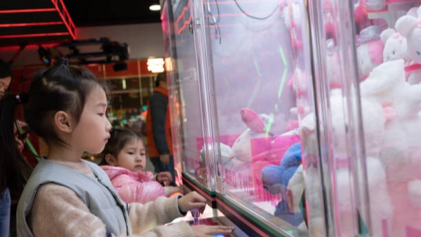 Best kids claw machine: Girl playing arcade game.