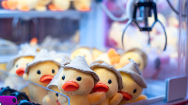 Good claw machine with adorable yellow duck plushies.