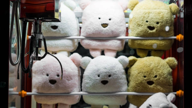 Arcade games claw machine filled with cute plush teddy bears.