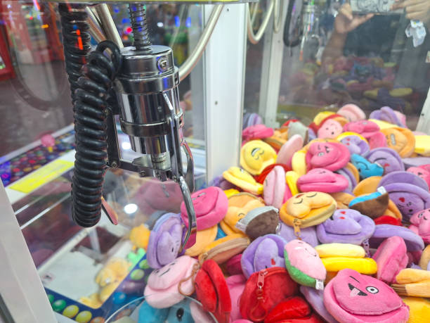 Toy candy claw machine filled with colorful plush toys.