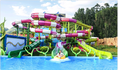 Water park with colorful slides, people on tube raft entering pool.