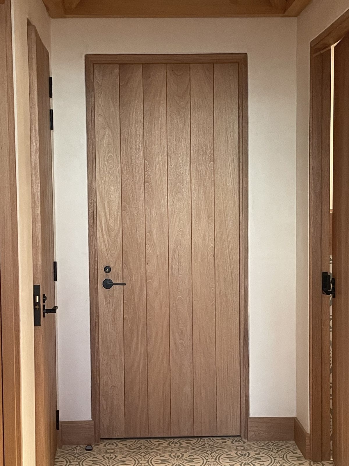 Interior view of a light wood paneled door with black hardware. Interior view of a light wood paneled door with black hardware.