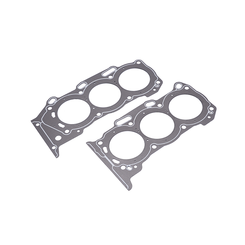 Two grey head gaskets for an internal combustion engine, featuring three large circular openings for cylinders.