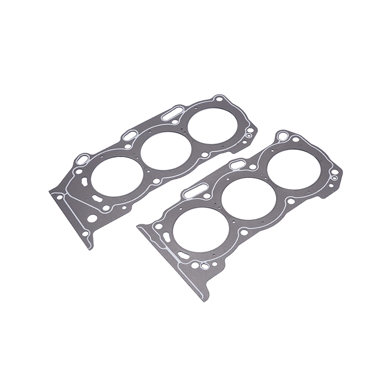 Two grey head gaskets for an internal combustion engine, featuring three large circular openings for cylinders.