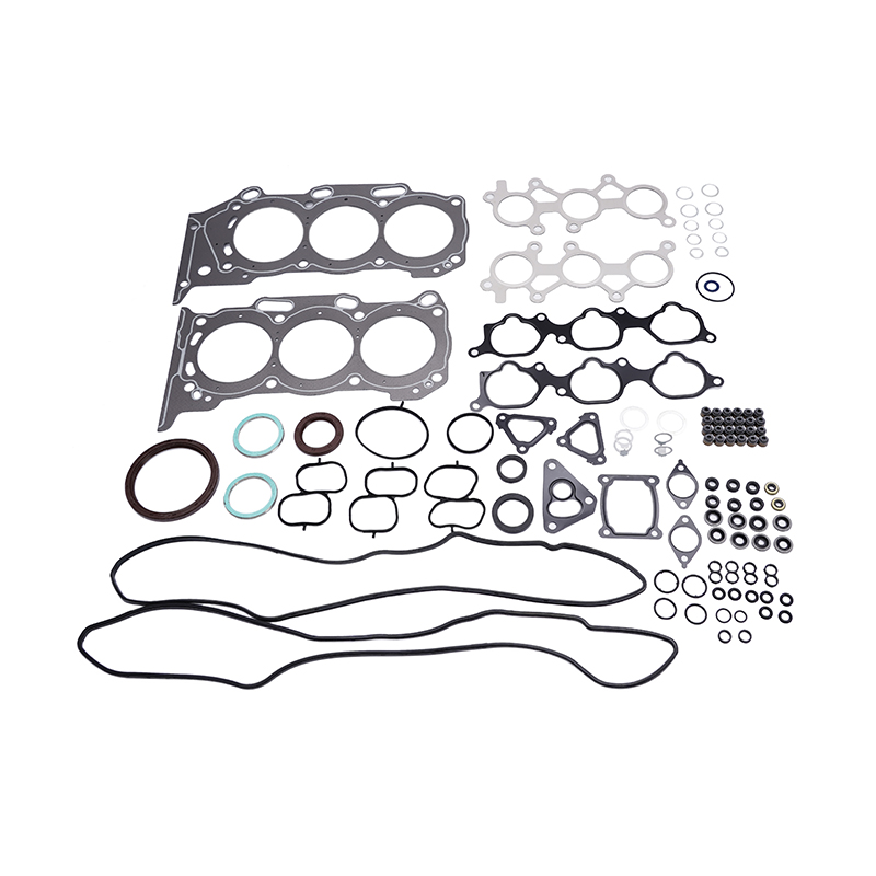 A comprehensive engine gasket set laid out on a white background, featuring head gaskets, intake and exhaust manifold gaskets, valve cover gaskets, and numerous O-rings and seals of varying sizes and materials.