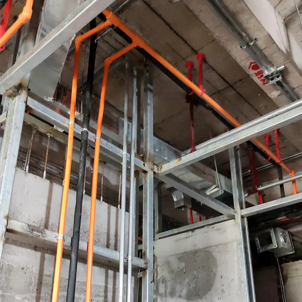 Exposed ceiling structure with organized orange electrical conduits, metal framing, and HVAC ductwork &mdash; precision engineering behind luxury interiors.