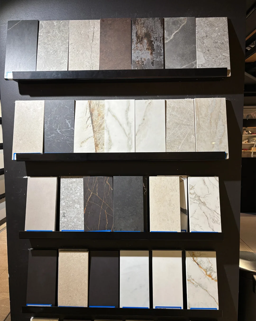 black-shelf-display-of-long-rectangular-marble-and-quartz-samples-for-hotel-walls-floors