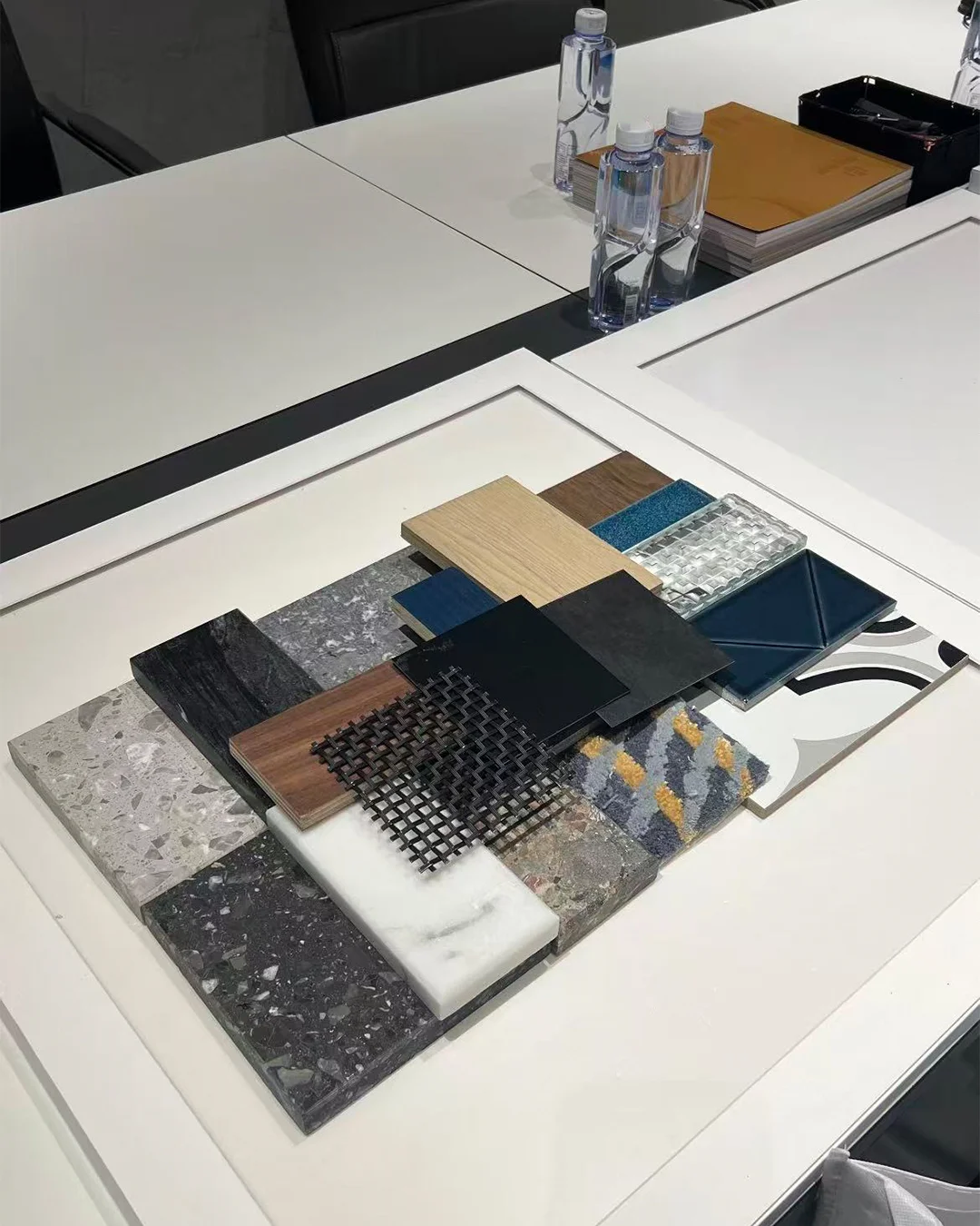 مجموعة عينات من مواد متنوعة على طاولة اجتماعات لمشاريع التصميم الداخلي للفنادق