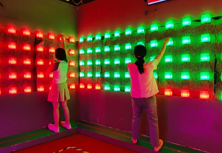 Digital dodgeball game room with illuminated target wall, soft throwing balls, timer, and automatic scoring system
