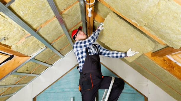 Worker installing rock wool comfort board in attic.