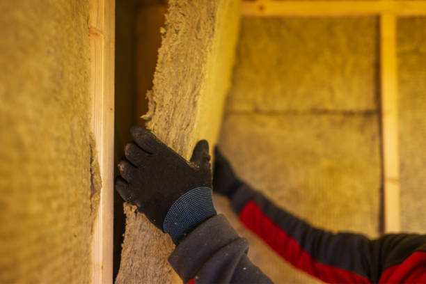 Worker installing mineral wool insulation.