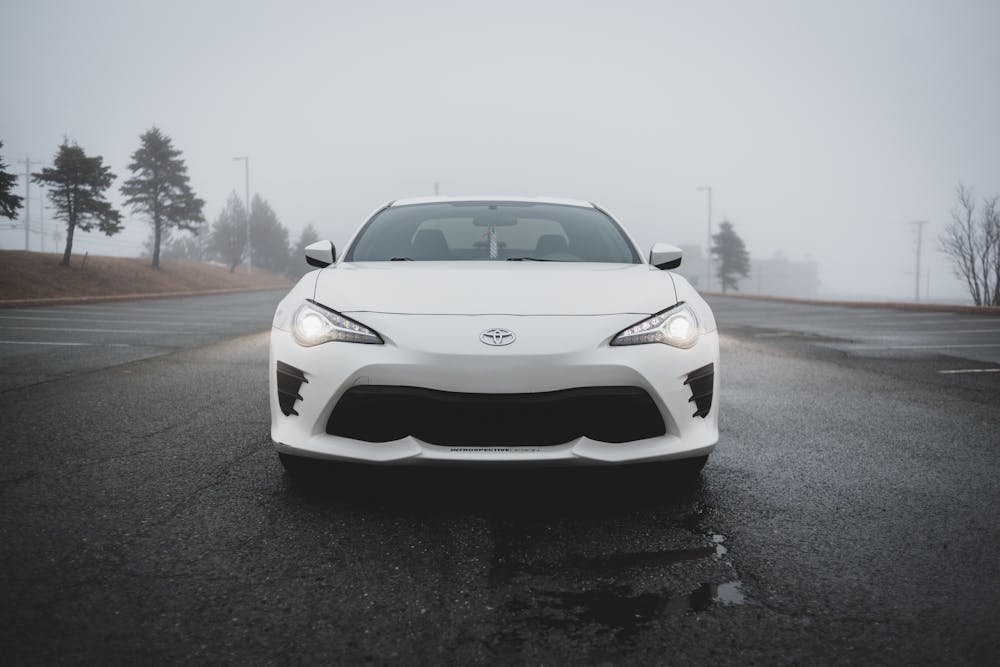 White car with bright led lights fog lights in fog.