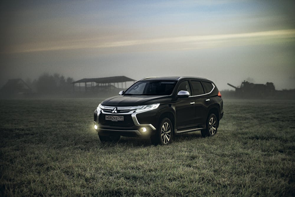 SUV on grassy field, lit by bright LED Fog Lights in foggy conditions.