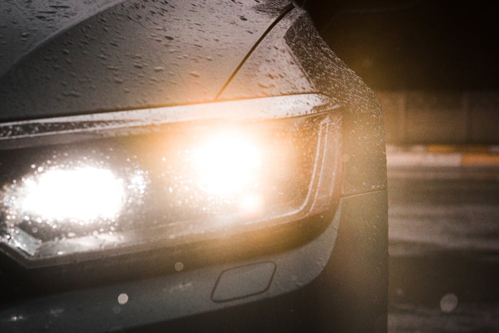 سيارة مزودة بمصابيح ضباب أمامية LED ساطعة في ليلة ممطرة.