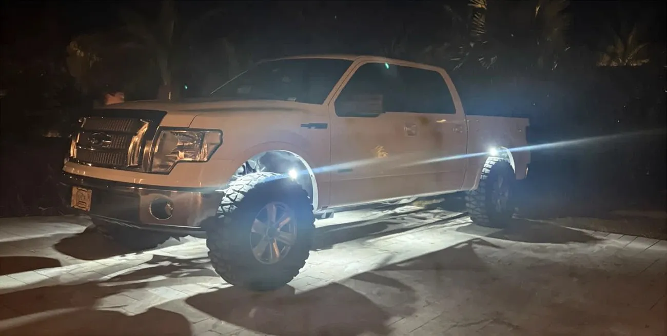 Weißer Ford F-150 mit Unterbodenbeleuchtung bei Nacht