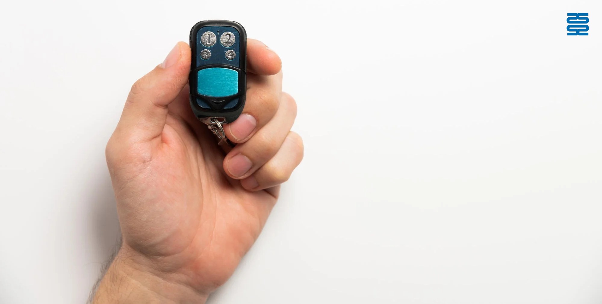 Hand holding a blue and black remote control with numbered buttons, against a white background. Hand holding a blue and black remote control with numbered buttons, against a white background.