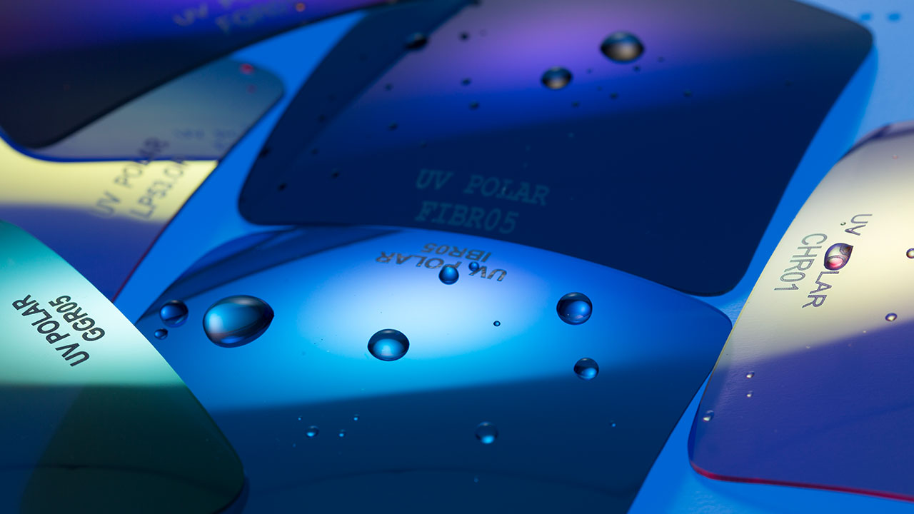 Polarized Close-up of UV Polar lens samples with water droplets under blue lighting.