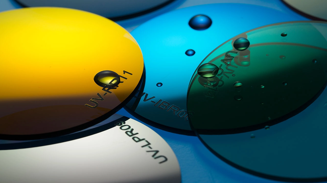 Close-up of colorful UV protective lenses with water droplets. - KARUSON