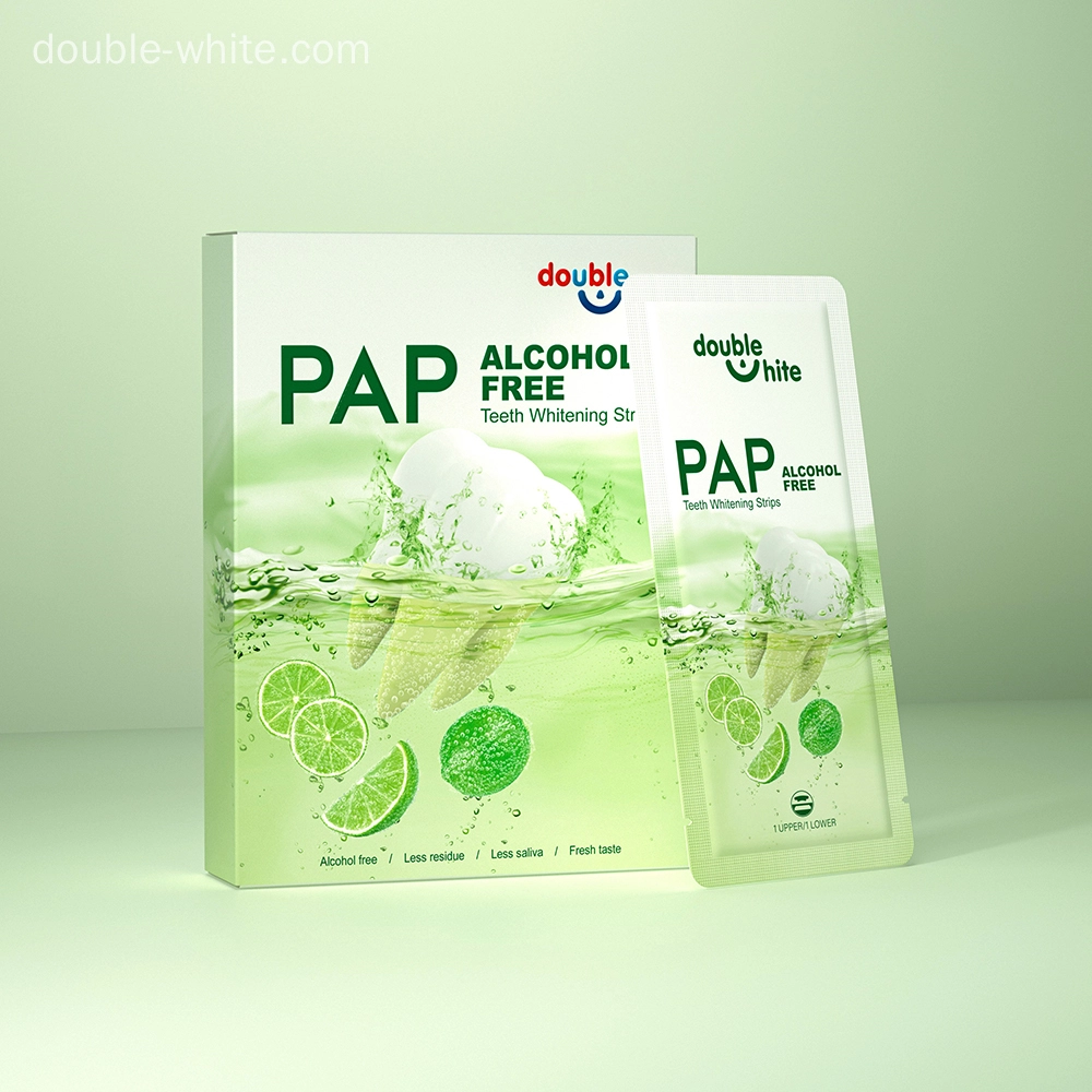 A box of Double White PAP+ Alcohol Free Teeth Whitening Strips. The box is green and white, and the strips are in a sealed packet.