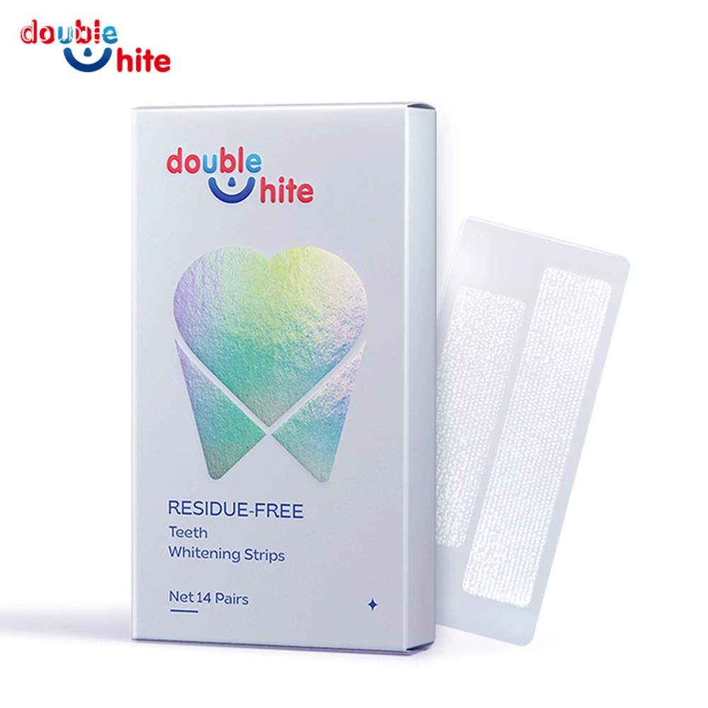 отбеливающие полоски вредны для зубов - Double White Коробка полосок для отбеливания зубов Double White. Коробка белая, с изображением зуба с градиентом в сине-розовых тонах на лицевой стороне. Надписи на упаковке: «Double White», «Residicone-Unix», «Teaching Strips» и «14 пар». — Double White