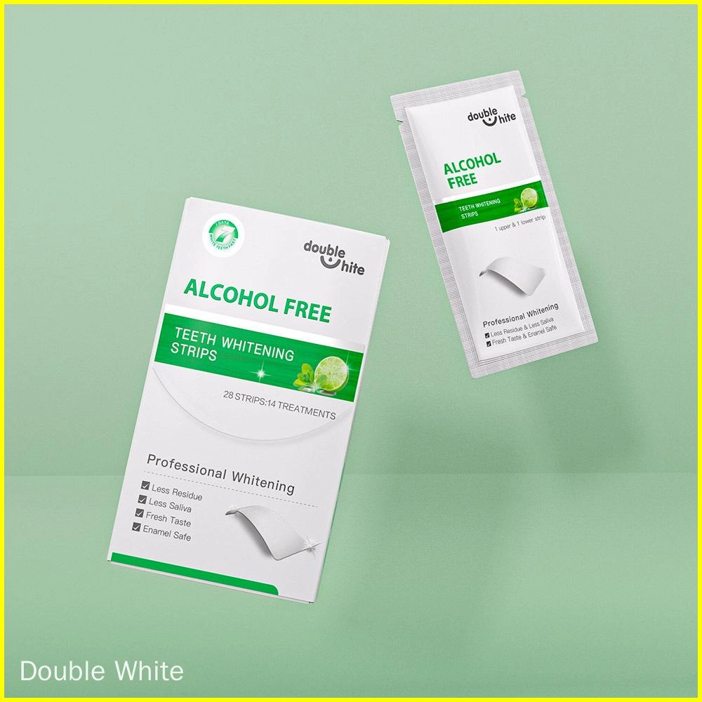 bandes-blanchissantes-sûres-pour-les-dents Une boîte de bandes de blanchiment des dents Double White contenant 28 bandes pour 14 traitements. Les bandes sont sans alcool et ont une saveur de menthe fraîche. L'emballage est blanc avec des accents verts et affiche le nom du produit, le logo et d'autres informations.