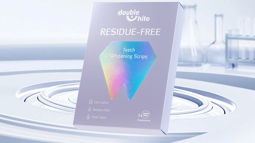 A box of Double White Residue Free Teeth Whitening Strips. The box is white and purple with a diamond-shaped window on the front.