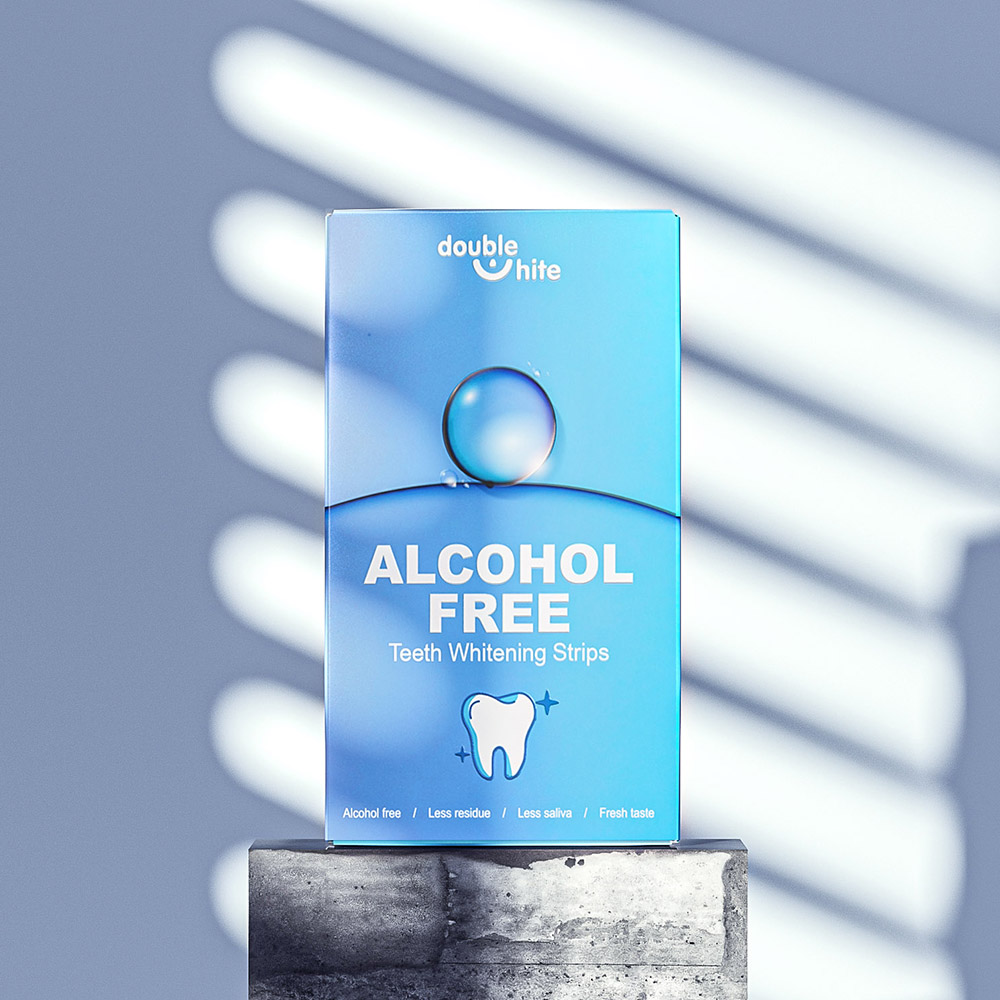 Una caja de tiras blanqueadoras de dientes Double White. La caja es azul y blanca, con el logotipo de Double White y el texto &quot;Sin alcohol&quot; en el frente.