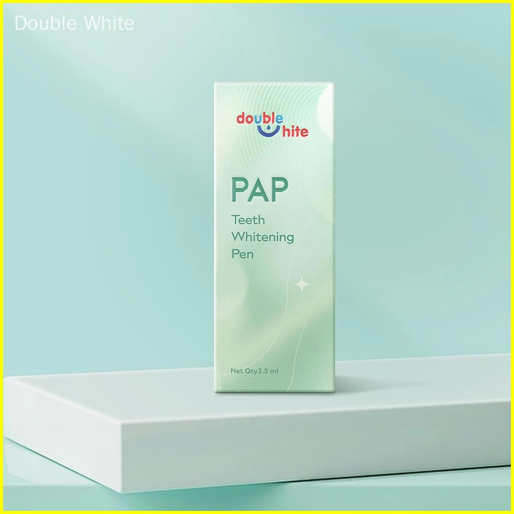 A small green and white box of Double White PAP Teeth Whitening Pen on a podium against a pale green background.