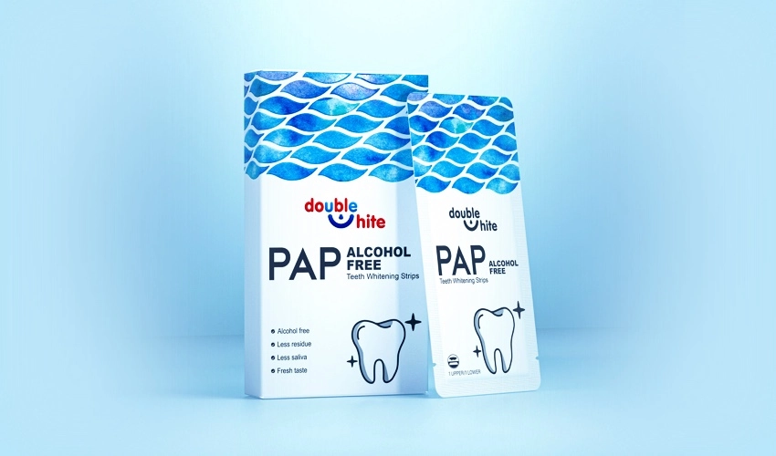 A box of Double White PAP+ Alcohol-Free Teeth Whitening Strips. The box is white and blue, and the strips are sealed in individual packets.