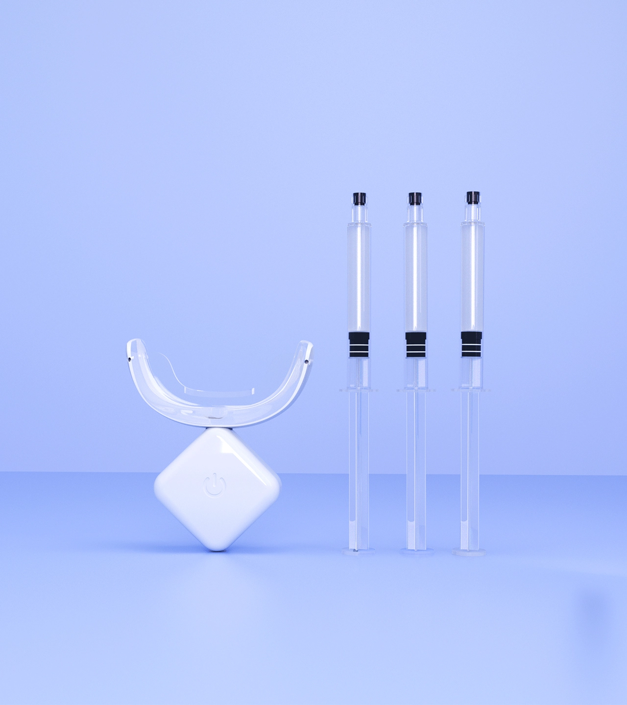 Imagen en primer plano de un kit de blanqueamiento dental. El kit incluye tres jeringas de gel blanqueador y una luz LED.