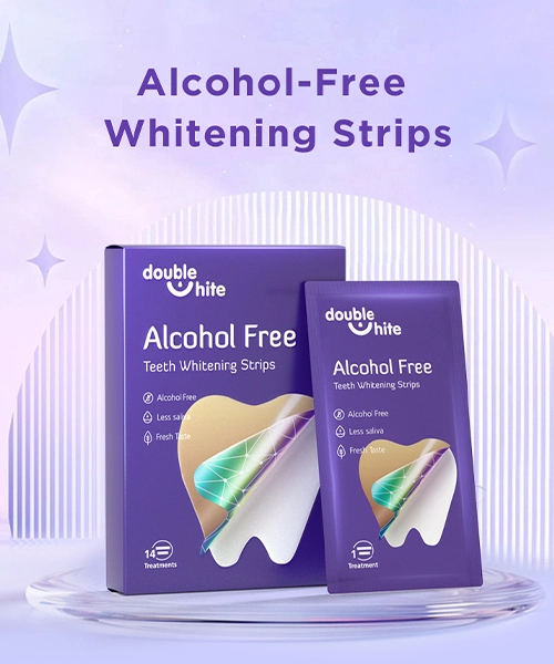 Double White Alcohol-Free Teeth Whitening Strips. Коробка имеет фиолетовый фон с прозрачным окошком, через которое видны полоски внутри. Текст на коробке белый и фиолетовый.