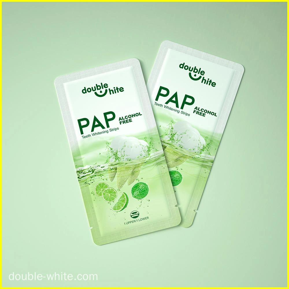 Dois pacotes de tiras de clareamento dental Double White PAP verdes e brancas em um fundo verde.