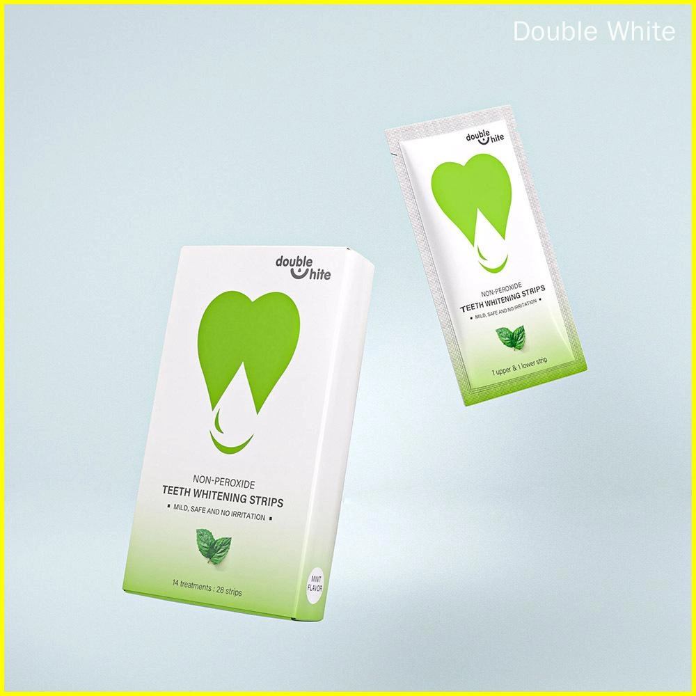 Une boîte de bandes de blanchiment des dents sans peroxyde Double White. La boîte est blanche et verte, et les bandes sont dans un sachet scellé.