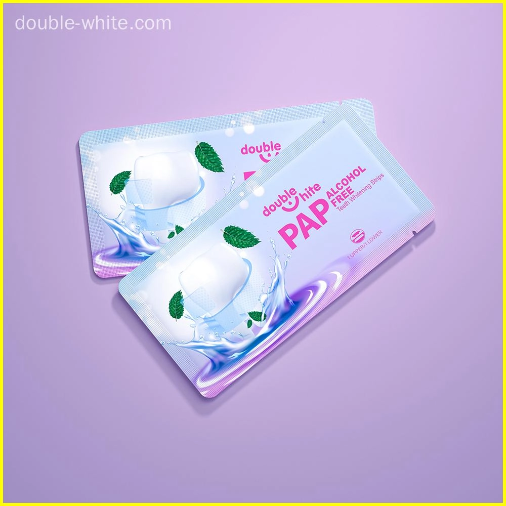 Uma imagem do produto Double White PAP Free Alcohol Free Teeth Whitening Strips. A embalagem é branca e roxa com uma imagem de uma boca sorridente com duas folhas verdes de hortelã.