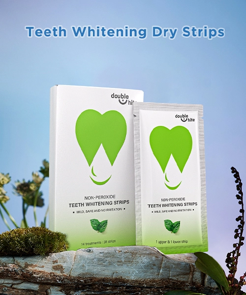 A box of Double White non-peroxide teeth whitening strips. The box is white with a green leaf design on the front. The strips are in a sealed packet inside the box.