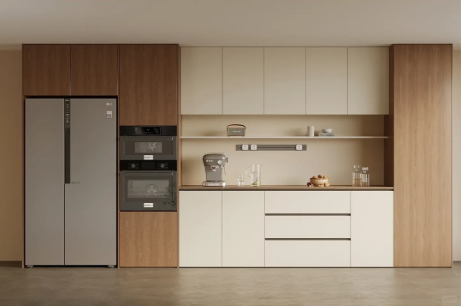 Modern minimalist kitchen with wood and cream cabinets and built-in appliances.