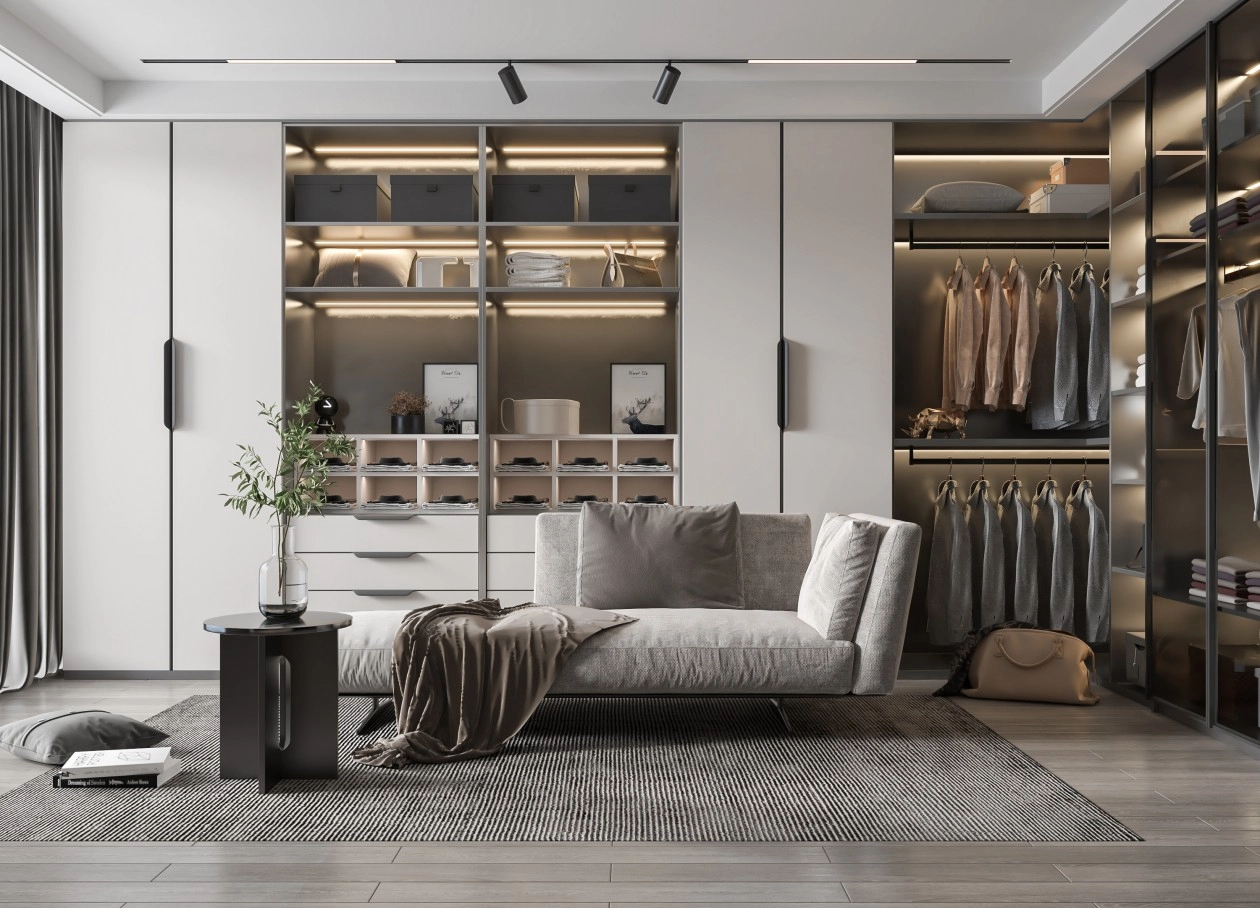 Modern walk-in closet with a gray sofa, soft rug, and illuminated shelving.