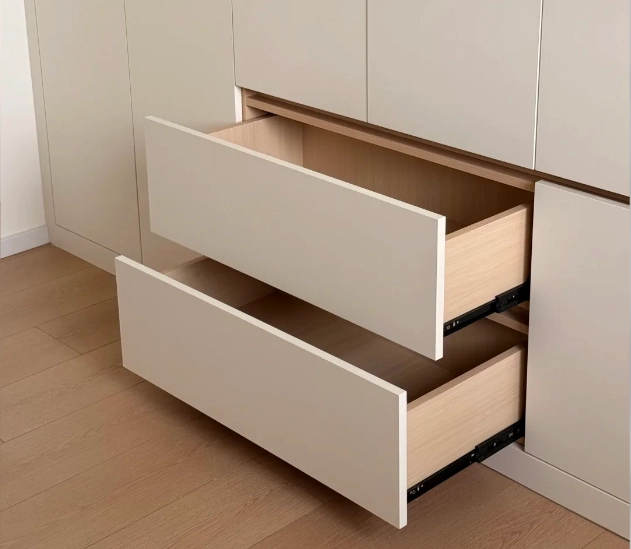 Two open white drawers with wooden interiors in a modern built-in cabinet.