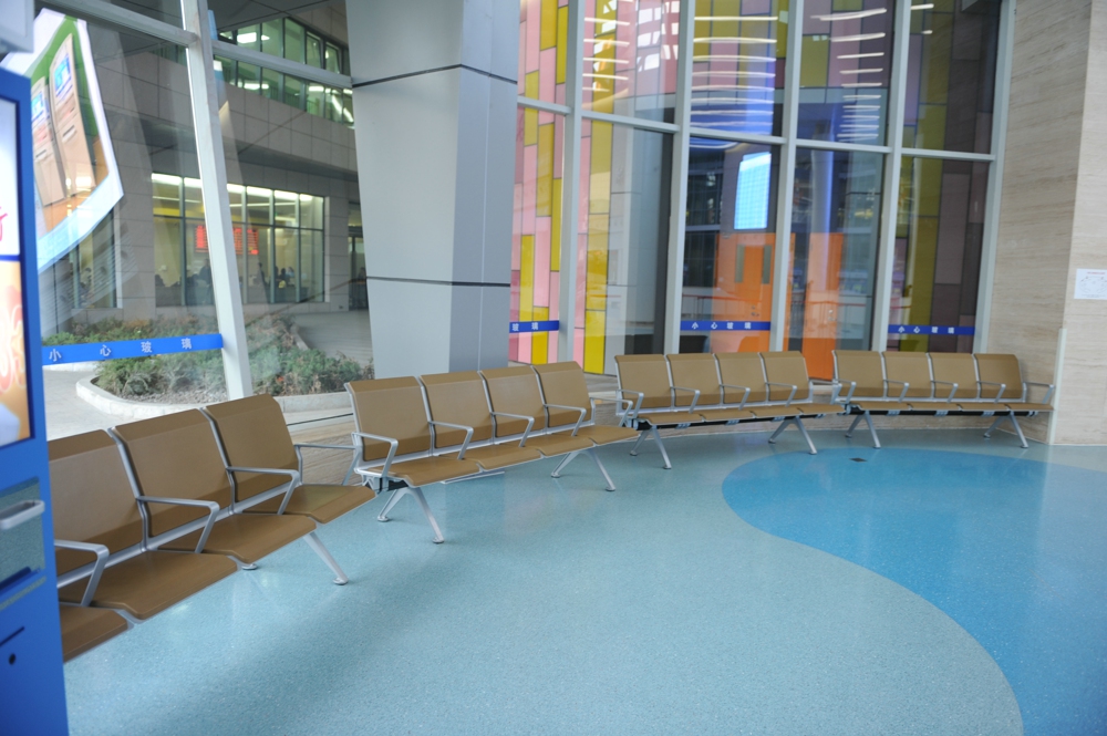 Modern waiting area with tan chairs in a bright, airy interior featuring large windows and colorful glass panels. Modern waiting area with tan chairs in a bright, airy interior featuring large windows and colorful glass panels.