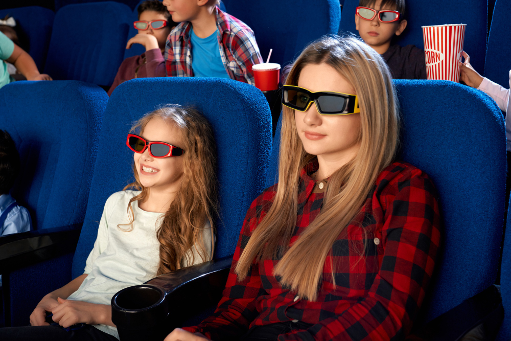 Experiencia de cine 5D: Una mujer joven y una niña disfrutan de una película usando gafas 3D.